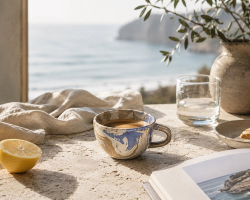 Handmade marbled ceramic espresso cups filled with coffee on a coastal-inspired stone table